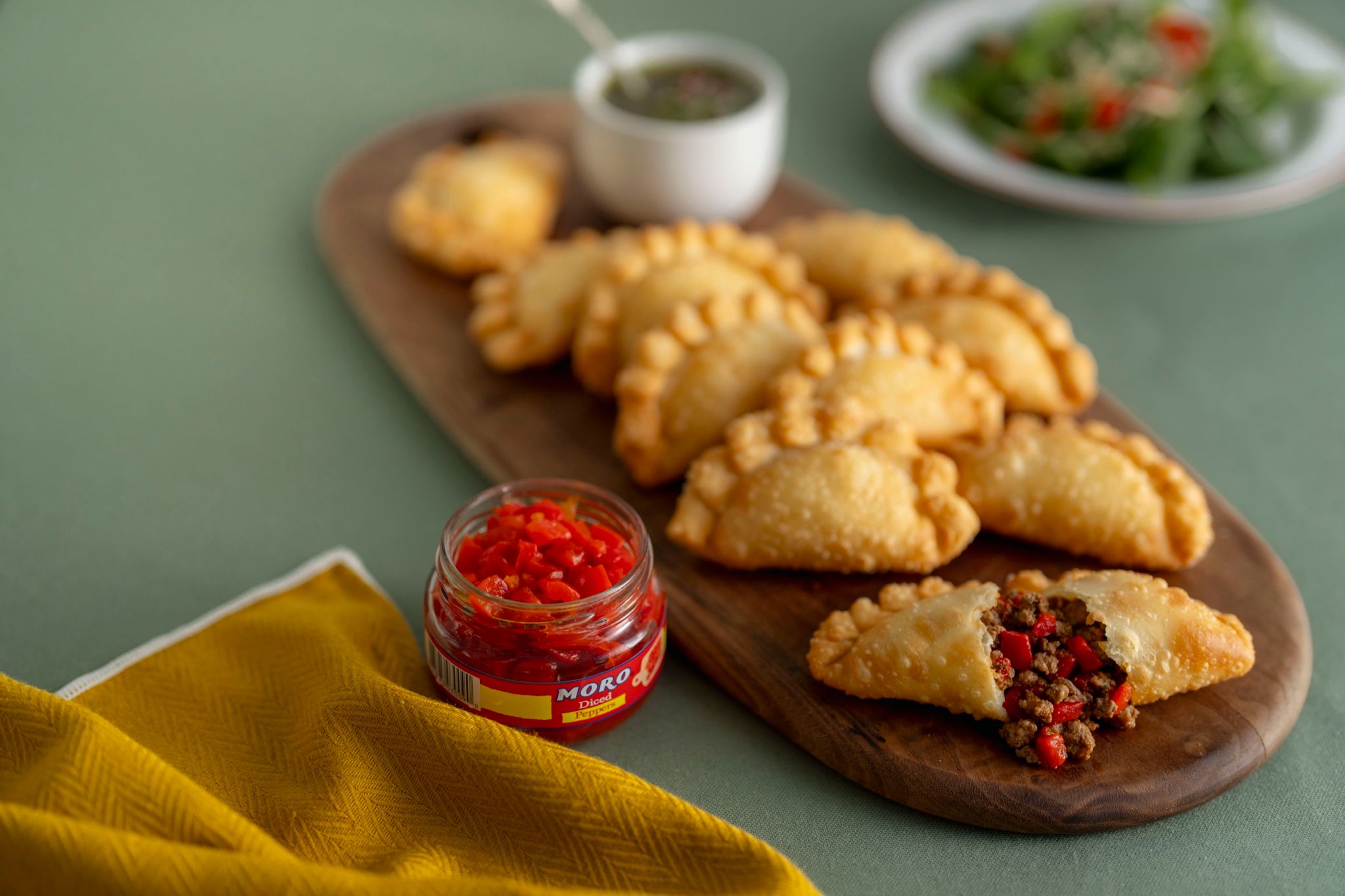 Empanadillas doradas en una tabla con salsa