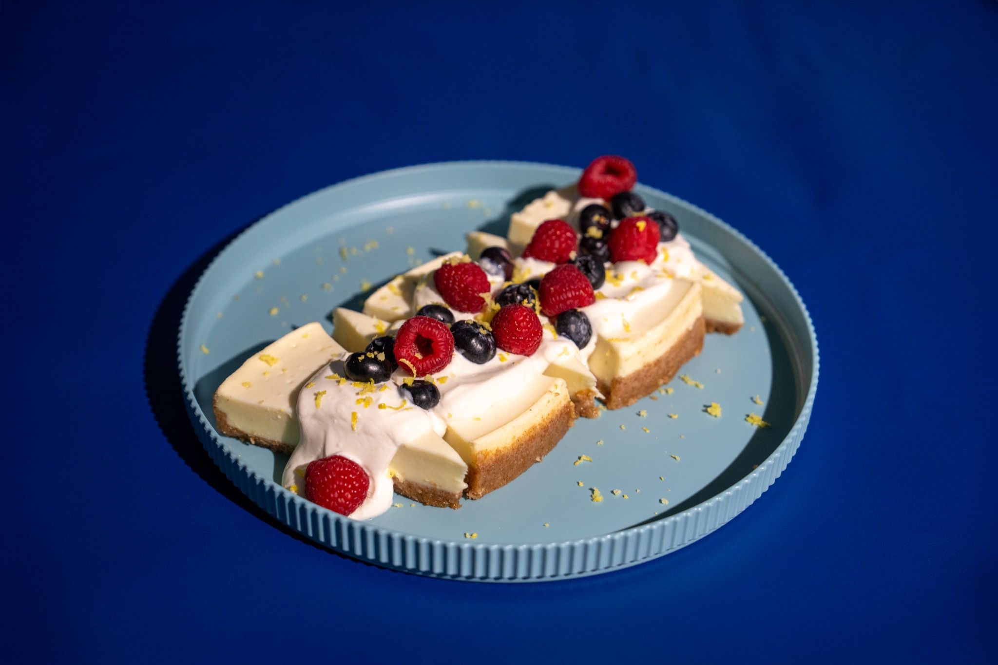 Postre con frutas rojas sobre plato azul